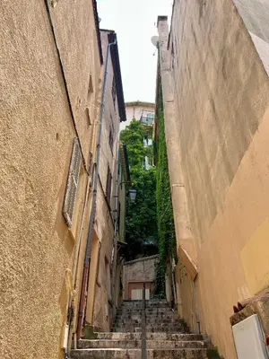 an alley with stairs in an alley between two buildings at Studio Vue Mer au coeur du Suquet in Cannes