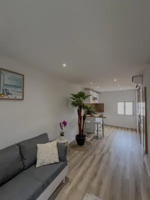 a living room with a couch and a table at Studio Vue Mer au coeur du Suquet in Cannes
