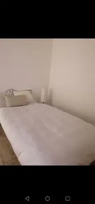 a white bed with two pillows on top of it at Apartment Cosy Shared Center of Cannes in Cannes