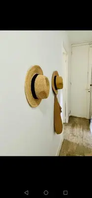 two straw hats and a tie hanging on a wall at Apartment Cosy Shared Center of Cannes in Cannes