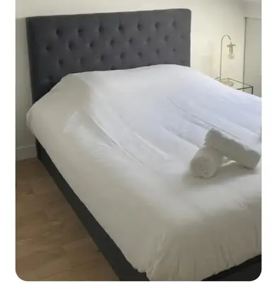 a white bed with a white object on it at Apartment Cosy Shared Center of Cannes in Cannes