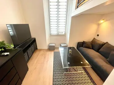 a living room with a couch and a table at Studio Neuf Clim 4p - Cannes in Cannes