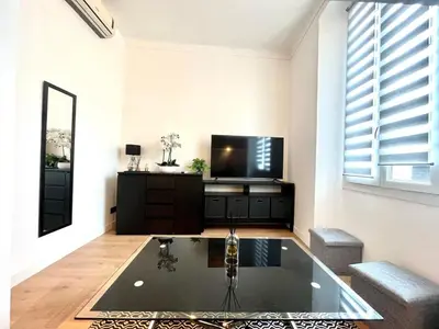 a living room with a tv and a glass table at Studio Neuf Clim 4p - Cannes in Cannes