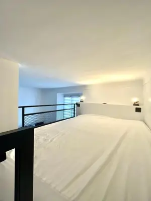 an empty room with a white bed in it at Studio Neuf Clim 4p - Cannes in Cannes