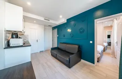 a living room with a couch and a blue wall at Close to train station and palace, quiet in Cannes
