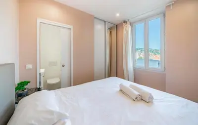 a bedroom with a white bed with two towels on it at Close to train station and palace, quiet in Cannes
