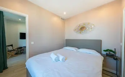 a bedroom with a white bed with a mirror on the wall at Close to train station and palace, quiet in Cannes