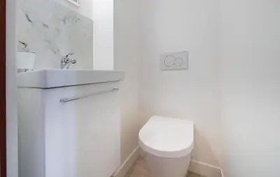 a white bathroom with a toilet and a sink at Close to train station and palace, quiet in Cannes