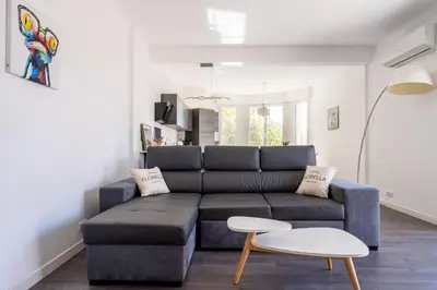a living room with a blue couch and a table at LE MADRID avec balcon proche Croisette plages et Palais des Festivals in Cannes