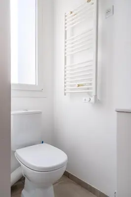 a white bathroom with a toilet and a window at LE MADRID avec balcon proche Croisette plages et Palais des Festivals in Cannes