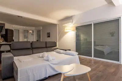 a living room with a large bed and a couch at LE MADRID avec balcon proche Croisette plages et Palais des Festivals in Cannes