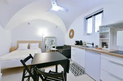 a kitchen and living room with a bed and a table at L'ESPERANCE Studio joli petit situé dans le Suquet, proche des commerces, Palais et plages in Cannes
