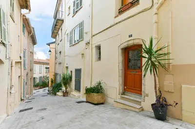 a street in an old town with a door at L'ESPERANCE Studio joli petit situé dans le Suquet, proche des commerces, Palais et plages in Cannes