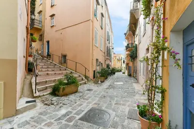 an empty street in an old town with flowers at L'ESPERANCE Studio joli petit situé dans le Suquet, proche des commerces, Palais et plages in Cannes