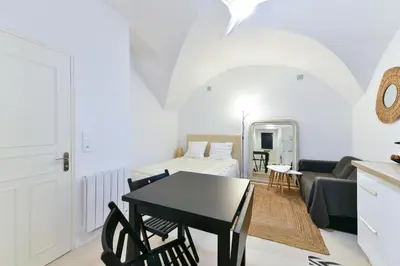 a living room with a table and a couch at L'ESPERANCE Studio joli petit situé dans le Suquet, proche des commerces, Palais et plages in Cannes