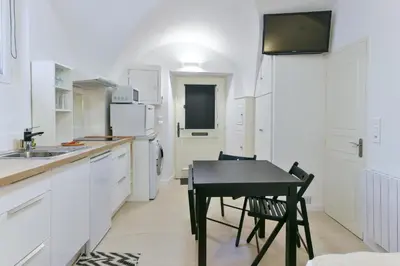 a kitchen with a black table and a black chair at L'ESPERANCE Studio joli petit situé dans le Suquet, proche des commerces, Palais et plages in Cannes