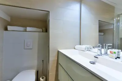 a bathroom with a sink and a mirror and a toilet at L'ESPERANCE Studio joli petit situé dans le Suquet, proche des commerces, Palais et plages in Cannes