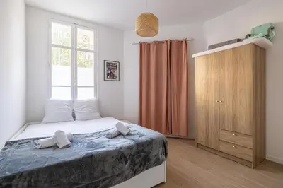 a bedroom with a bed with two towels on it at LE WINDSOR avec extérieur, spacieux et chaleureux pour un plaisir partagé in Cannes
