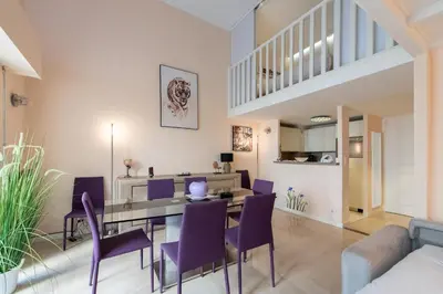 a dining room with a table and purple chairs at LE RIMBAUD splendide duplex dans le Suquet, près des plages et du Palais des Festivals in Cannes