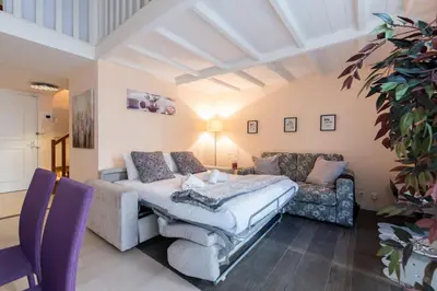 a living room with a couch and a table at LE RIMBAUD splendide duplex dans le Suquet, près des plages et du Palais des Festivals in Cannes