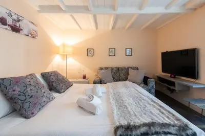 a bedroom with a white bed and a flat screen tv at LE RIMBAUD splendide duplex dans le Suquet, près des plages et du Palais des Festivals in Cannes
