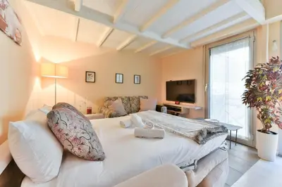 a bedroom with a large white bed and a couch at LE RIMBAUD splendide duplex dans le Suquet, près des plages et du Palais des Festivals in Cannes