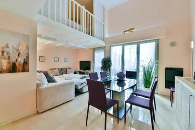 a living room with a table and chairs and a couch at LE RIMBAUD splendide duplex dans le Suquet, près des plages et du Palais des Festivals in Cannes