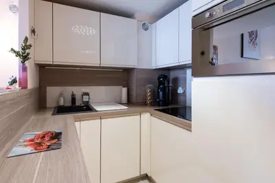 a kitchen with white cabinets and a refrigerator at LE RIMBAUD splendide duplex dans le Suquet, près des plages et du Palais des Festivals in Cannes