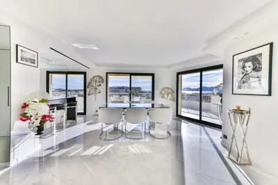 a white living room with a table and chairs at L'HORIZON avec somptueuse terrasse vue mer in Cannes
