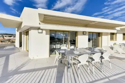 a table and chairs on the deck of a house at L'HORIZON avec somptueuse terrasse vue mer in Cannes