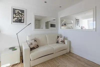 a white living room with a couch and mirrors at LE VANILLE studio cosy au cœur de la Banane in Cannes