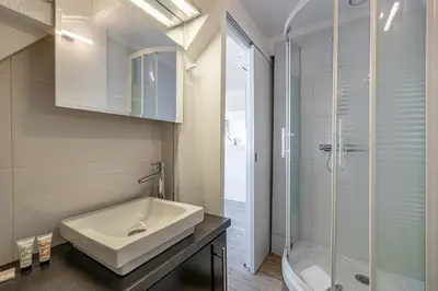 a bathroom with a sink and a glass shower at LE VANILLE studio cosy au cœur de la Banane in Cannes
