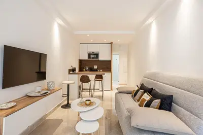 a living room with a couch and a table at LE CENTER avec joli balcon et parking pour un plaisant séjour in Cannes