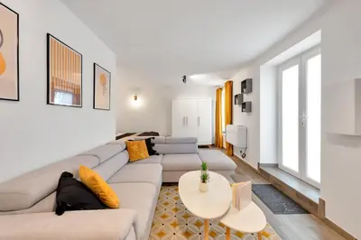 a living room with a couch and a table at LE PALME D'OR splendide studio cocon près de la Croisette, du Palais et des plages in Cannes