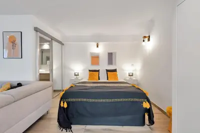a bedroom with a bed and a couch at LE PALME D'OR splendide studio cocon près de la Croisette, du Palais et des plages in Cannes