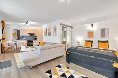 a bedroom with a king sized bed and a living room at LE PALME D'OR splendide studio cocon près de la Croisette, du Palais et des plages in Cannes