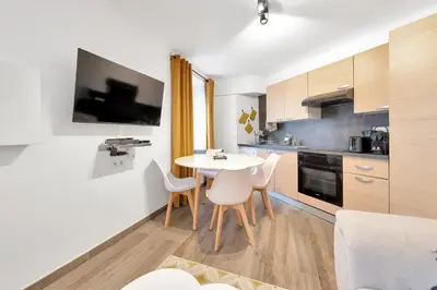 a kitchen with a table and chairs in a room at LE PALME D'OR splendide studio cocon près de la Croisette, du Palais et des plages in Cannes
