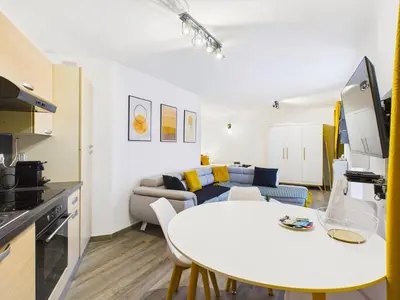 a living room with a white table and a couch at LE PALME D'OR splendide studio cocon près de la Croisette, du Palais et des plages in Cannes