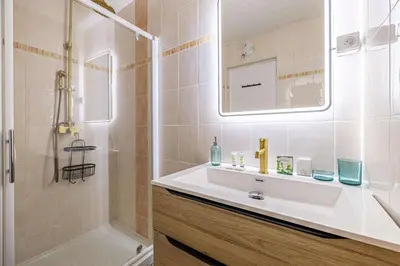 a bathroom with a white sink and a shower at LA PALMERAIE joyeux studio avec balcon, à deux pas de la Banane in Cannes