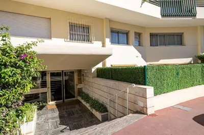 a building with a staircase in front of it at LA PALMERAIE joyeux studio avec balcon, à deux pas de la Banane in Cannes