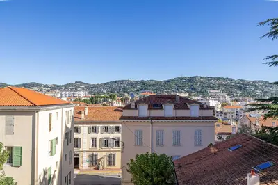 a view of a city with buildings and mountains at LA PALMERAIE joyeux studio avec balcon, à deux pas de la Banane in Cannes