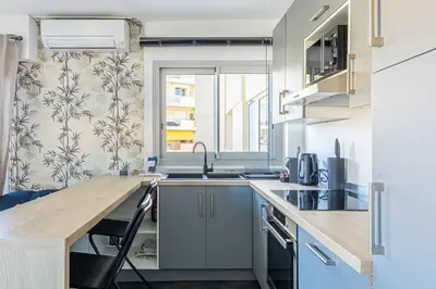 a kitchen with a wooden counter top and a sink at LA PALMERAIE joyeux studio avec balcon, à deux pas de la Banane in Cannes
