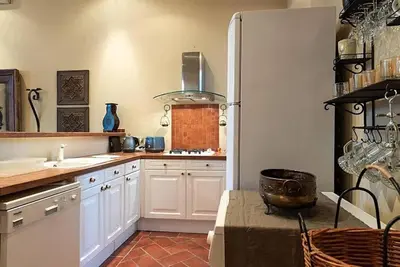 a kitchen with white cabinets and a counter top at L'AUTHENTIQUE charme rustique et rétro proche Croisette et plages in Cannes