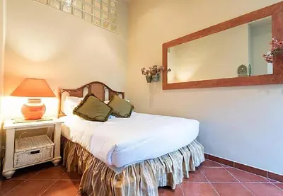 a bedroom with a bed with a mirror and a lamp at L'AUTHENTIQUE charme rustique et rétro proche Croisette et plages in Cannes