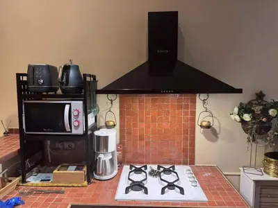 a kitchen with a stove top oven and a microwave at L'AUTHENTIQUE charme rustique et rétro proche Croisette et plages in Cannes