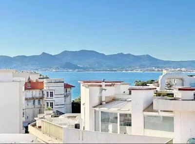 a view of the ocean from the roofs of buildings at Duplex centre de Cannes - terrasse, sunset & pool in Cannes