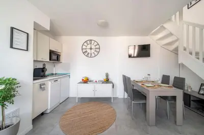 a kitchen and dining room with a table and a dining room gmaxwell gmaxwell at Duplex centre de Cannes - terrasse, sunset & pool in Cannes