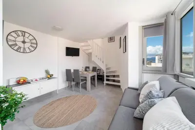 a living room with a couch and a dining room at Duplex centre de Cannes - terrasse, sunset & pool in Cannes