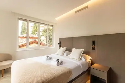 a bedroom with a large white bed with a window at Elégant et moderne T4 à 100M de La Croisette in Cannes