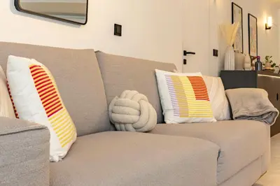 a couch with pillows and a stuffed animal on it at Elégant et moderne T4 à 100M de La Croisette in Cannes